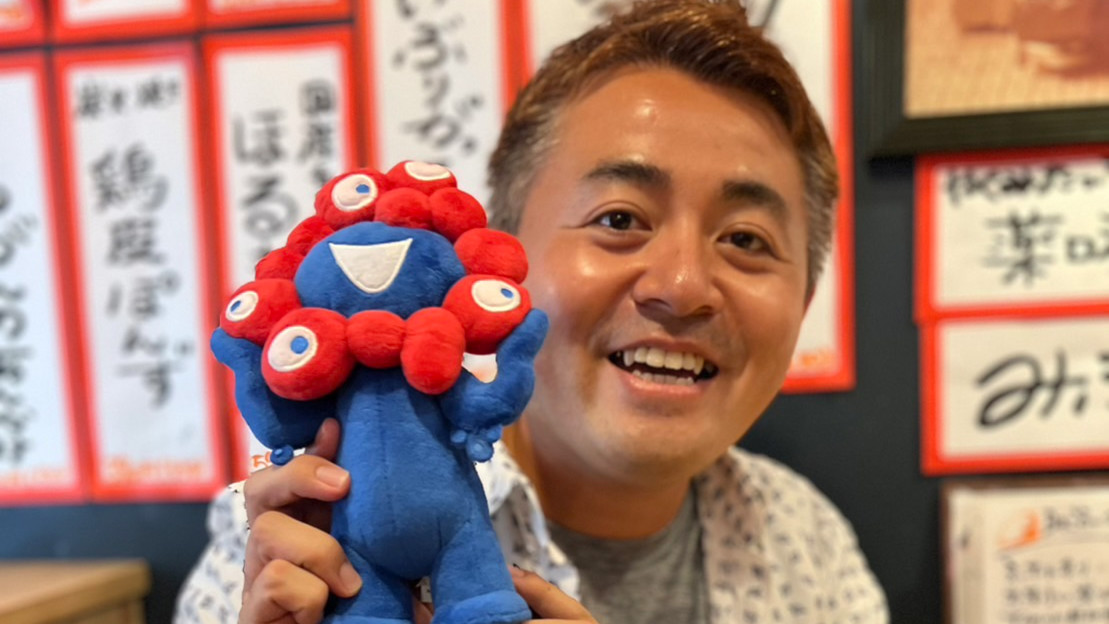 ワクセル(主催:嶋村吉洋)総合プロデューサーの住谷知厚(すみたにともひろ)さんが大阪の日本酒居酒屋にて、大阪万博を応援しながらコラボレーターの方と乾杯んしている様子